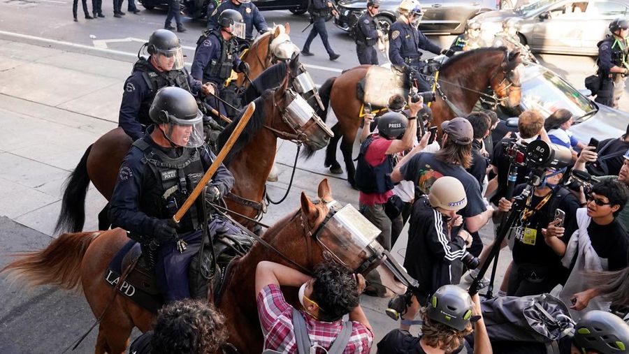 USA-MIGRATION/PROTEST-LOS ANGELES Police officers ride horses as they attempt to disperse protesters demonstrating against federal immigration sweeps, in downtown Los Angeles, California, U.S. June 11, 2025. REUTERS/David Ryder