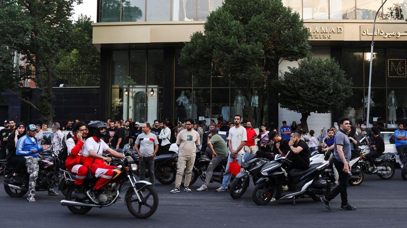 Orang-orang berkumpul di jalan setelah serangan Israel, di Teheran, Iran, 13 Juni 2025. (via REUTERS/Majid Asgaripour)