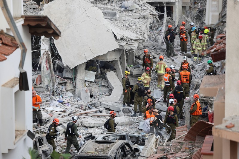 Petugas penyelamat bekerja di lokasi dampak setelah serangan rudal dari Iran terhadap Israel, di Rishon LeZion, Israel, 14 Juni 2025. Petugas penyelamat bekerja di lokasi dampak setelah serangan rudal dari Iran terhadap Israel, di Rishon LeZion, Israel, 14 Juni 2025. (REUTERS/Ronen Zvulun)