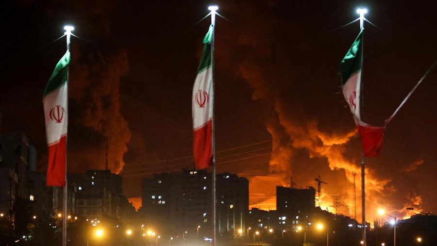 Orang-orang menyaksikan dari jembatan saat api dari serangan Israel membubung dari depot minyak Sharan, menyusul serangan Israel terhadap Iran, di Teheran, Iran, 15 Juni 2025. Orang-orang menyaksikan dari jembatan saat api dari serangan Israel membubung dari depot minyak Sharan, menyusul serangan Israel terhadap Iran, di Teheran, Iran, 15 Juni 2025. (Majid Asgaripour/WANA (West Asia News Agency) via REUTERS)