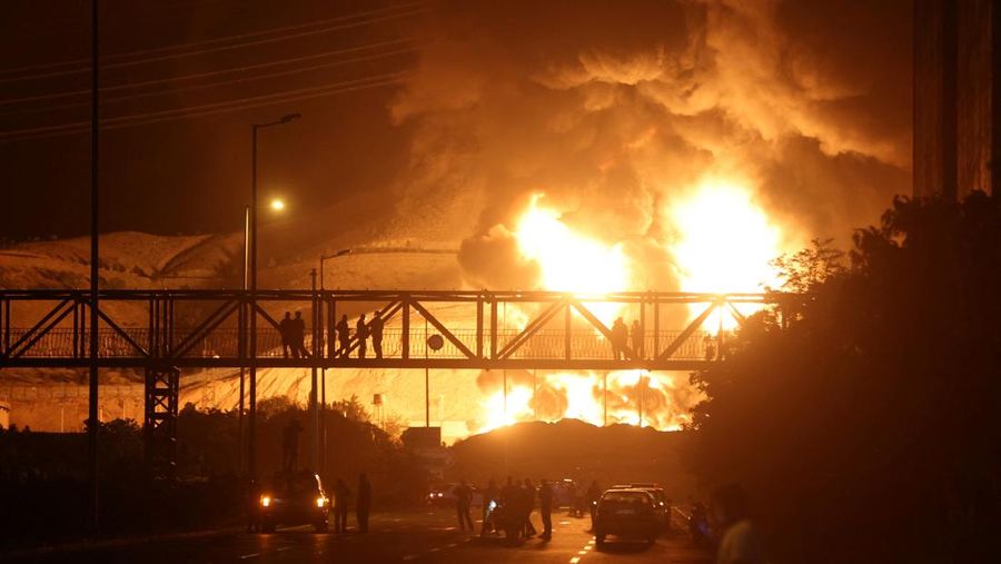 Orang-orang menyaksikan dari jembatan saat api dari serangan Israel membubung dari depot minyak Sharan, menyusul serangan Israel terhadap Iran, di Teheran, Iran, 15 Juni 2025. Orang-orang menyaksikan dari jembatan saat api dari serangan Israel membubung dari depot minyak Sharan, menyusul serangan Israel terhadap Iran, di Teheran, Iran, 15 Juni 2025. (Majid Asgaripour/WANA (West Asia News Agency) via REUTERS)