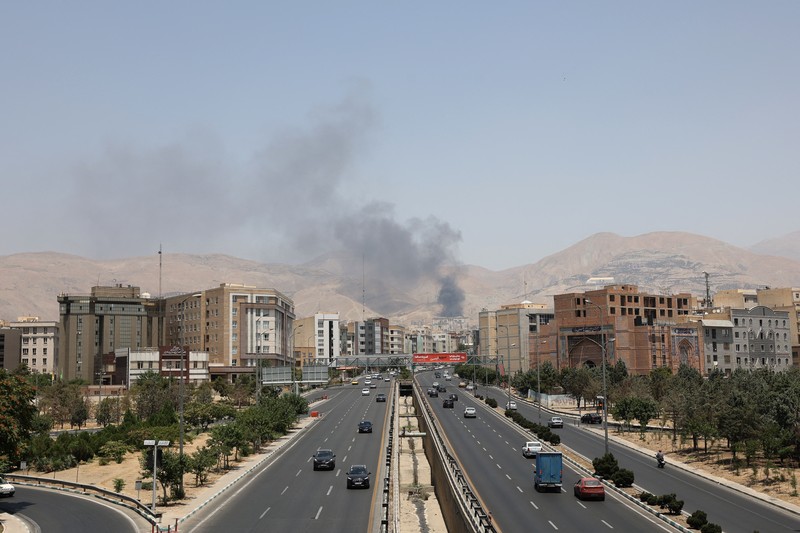 Asap mengepul menyusul apa yang dikatakan Iran sebagai serangan Israel terhadap depot minyak Sharan di Teheran, Iran, Senin (16/6/2025). (Majid Asgaripour/WANA via REUTERS)