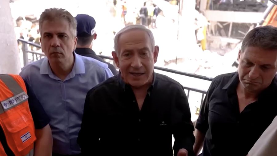 Perdana Menteri Israel Benjamin Netanyahu mengunjungi lokasi daerah permukiman yang hancur akibat serangan rudal Iran di dekat Tel Aviv, Israel, Minggu (15/6/2025). (Tangkapan Layar Video/REUTERS)