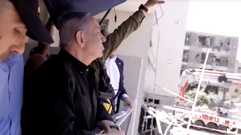 Perdana Menteri Israel Benjamin Netanyahu mengunjungi lokasi daerah permukiman yang hancur akibat serangan rudal Iran di dekat Tel Aviv, Israel, Minggu (15/6/2025). (Tangkapan Layar Video/REUTERS)