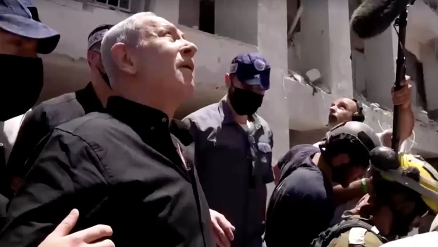 Perdana Menteri Israel Benjamin Netanyahu mengunjungi lokasi daerah permukiman yang hancur akibat serangan rudal Iran di dekat Tel Aviv, Israel, Minggu (15/6/2025). (Tangkapan Layar Video/REUTERS)