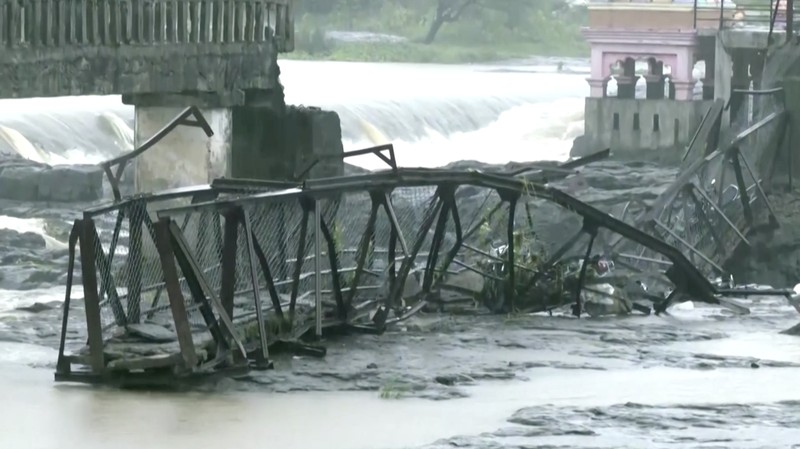 Sebuah tragedi terjadi di kota Pune, India barat, setelah jembatan di atas sungai Indrayani runtuh pada hari Minggu (15/6). Insiden ini mengakibatkan setidaknya dua orang tewas dan sejumlah lainnya tersapu arus sungai. (Tangkapan Layar Video Reuters/ANI)