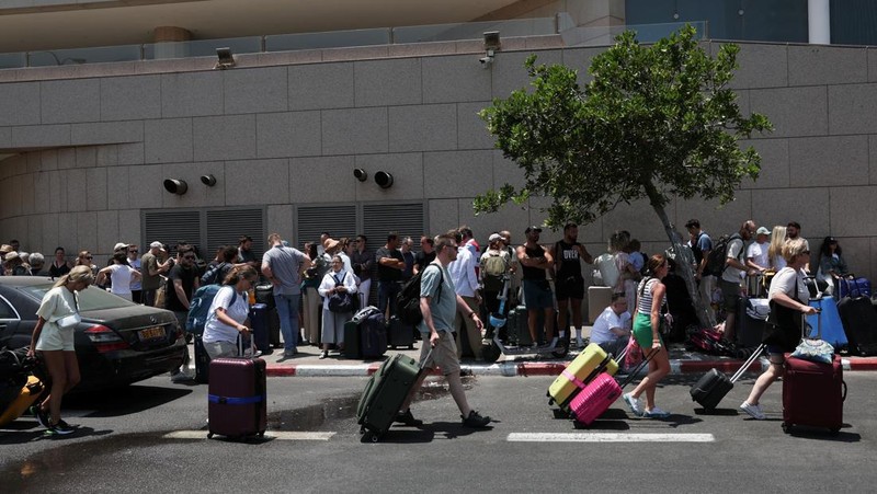 ang-orang dengan kewarganegaraan asing berkumpul untuk meninggalkan Israel dengan bus melalui Mesir, setelah serangan rudal dari Iran, di Tel Aviv, Israel, Selasa (17/6/2925). (REUTERS/Ronen Zvulun)