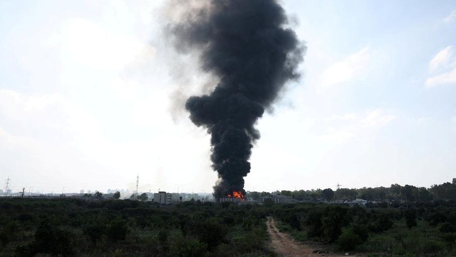 Petugas pemadam kebakaran berupaya memadamkan api di sebuah bus setelah serangan rudal dari Iran, di Herzliya, Israel, Selasa (17/6/2025). (REUTERS/Ronen Zvulun)