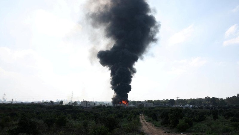 Petugas pemadam kebakaran berupaya memadamkan api di sebuah bus setelah serangan rudal dari Iran, di Herzliya, Israel, Selasa (17/6/2025). (REUTERS/Ronen Zvulun)
