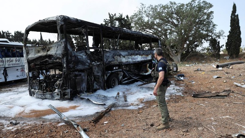 Petugas pemadam kebakaran berupaya memadamkan api di sebuah bus setelah serangan rudal dari Iran, di Herzliya, Israel, Selasa (17/6/2025). (REUTERS/Ronen Zvulun)