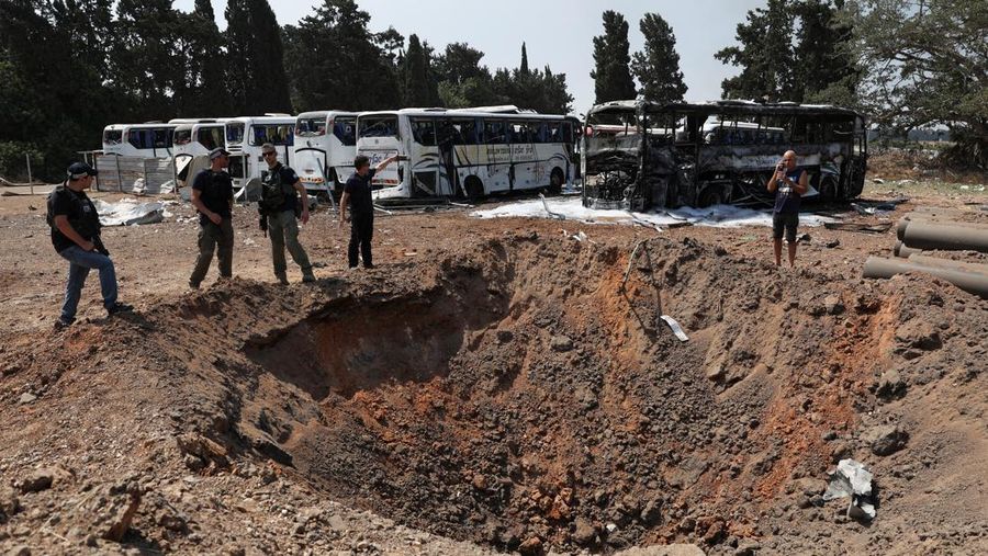Petugas pemadam kebakaran berupaya memadamkan api di sebuah bus setelah serangan rudal dari Iran, di Herzliya, Israel, Selasa (17/6/2025). (REUTERS/Ronen Zvulun)