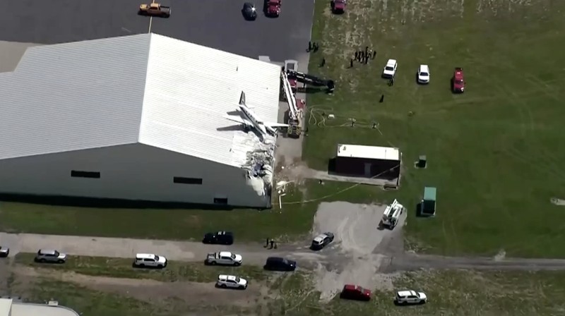 Sebuah pesawat jatuh dan tersangkut di atas atap sebuah hanggar dalam sebuah insiden mengejutkan yang terjadi di Bandara New Century, AS Senin (16/6/2025). (Tangkapan Layar Video Reuters/ABC AFFILIATE KMBC)
