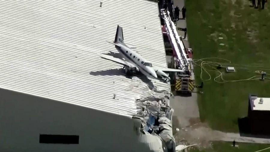 Sebuah pesawat jatuh dan tersangkut di atas atap sebuah hanggar dalam sebuah insiden mengejutkan yang terjadi di Bandara New Century, AS Senin (16/6/2025). (Tangkapan Layar Video Reuters/ABC AFFILIATE KMBC)