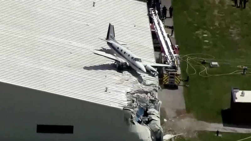 Sebuah pesawat jatuh dan tersangkut di atas atap sebuah hanggar dalam sebuah insiden mengejutkan yang terjadi di Bandara New Century, AS Senin (16/6/2025). (Tangkapan Layar Video Reuters/ABC AFFILIATE KMBC)