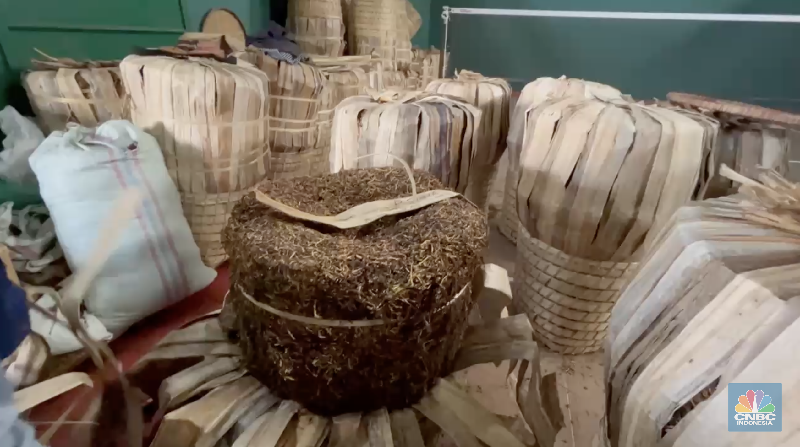 Seorang petani tembakau menata tembakaunya untuk disimpan di gudang penyimpanan di Temanggung, Jawa Tengah, Selasa (17/6/2025). (CNBC Indonesia/Tasya Natalia)