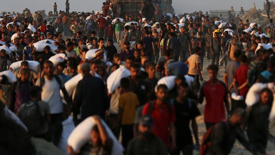 Warga Palestina berkumpul untuk menerima pasokan bantuan di Beit Lahia, di Jalur Gaza utara, Selasa (17/6/2025). (REUTERS/Stringer)