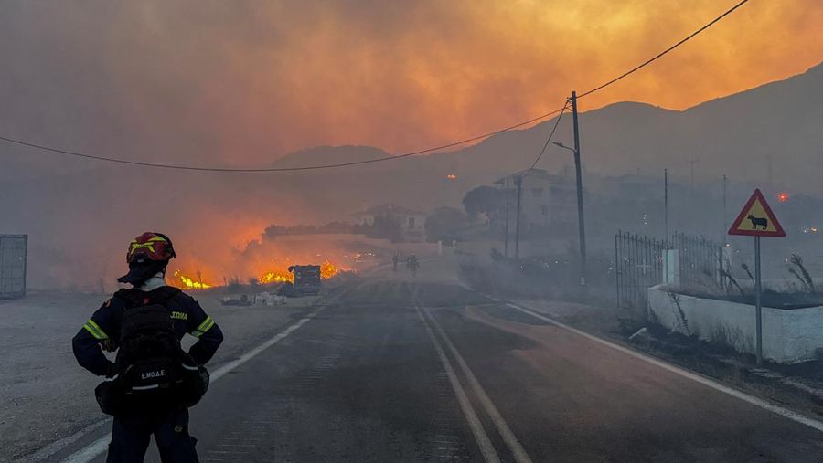 Petugas pemadam kebakaran bekerja untuk memadamkan kebakaran hutan, yang dipicu oleh angin kencang, yang menyebabkan munculnya pesan evakuasi di dekat desa Karyes di pulau Chios, Yunani, 22 Juni 2025. (REUTERS/Kostas Anagnostou)