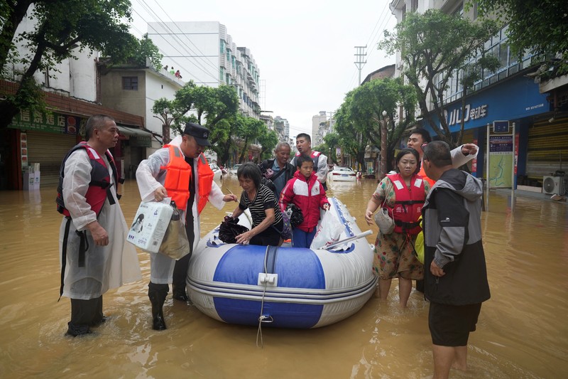 Petugas penyelamat mengevakuasi warga yang terdampak banjir dengan perahu di daerah Rongjiang, provinsi Guizhou, Tiongkok, 24 Juni 2025. China Daily via REUTERS