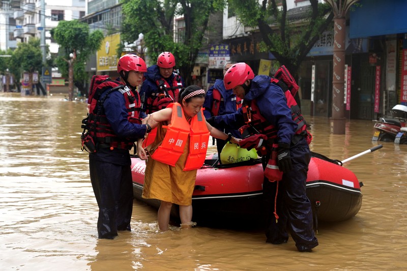 Petugas penyelamat mengevakuasi warga yang terdampak banjir dengan perahu di daerah Rongjiang, provinsi Guizhou, Tiongkok, 24 Juni 2025. China Daily via REUTERS