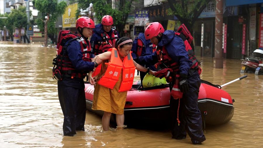 Petugas penyelamat mengevakuasi warga yang terdampak banjir dengan perahu di daerah Rongjiang, provinsi Guizhou, Tiongkok, 24 Juni 2025. China Daily via REUTERS