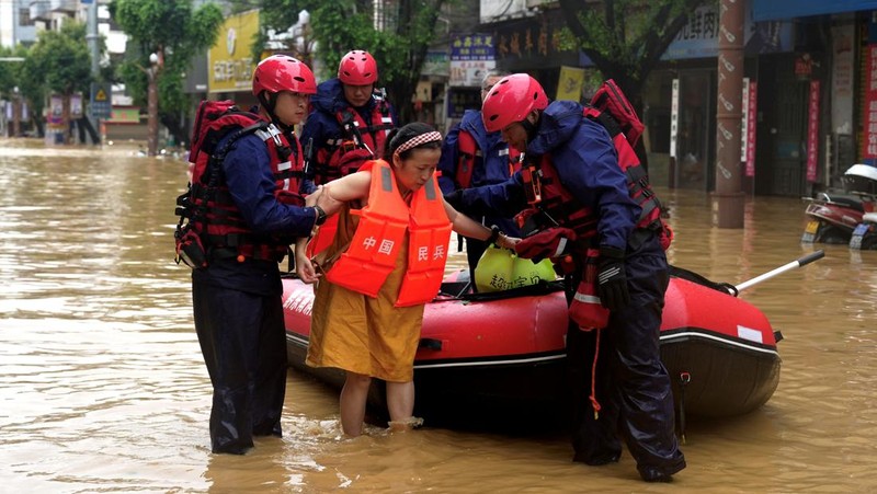 Petugas penyelamat mengevakuasi warga yang terdampak banjir dengan perahu di daerah Rongjiang, provinsi Guizhou, Tiongkok, 24 Juni 2025. China Daily via REUTERS