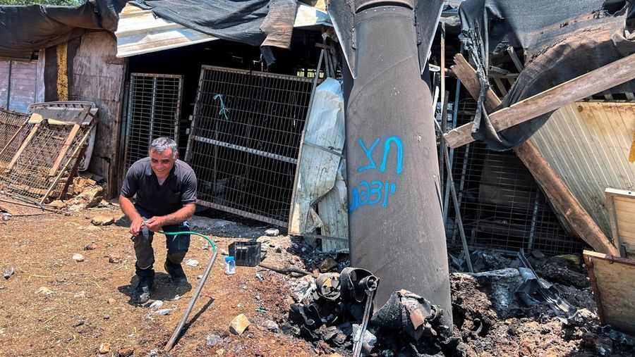 Seorang pria berpose di samping sisa-sisa rudal balistik setelah serangan rudal Iran terhadap Israel, di Israel utara, 24 Juni 2025. REUTERS/Avi Ohayon