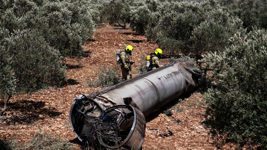 Orang-orang melihat sisa-sisa rudal balistik setelah serangan rudal Iran terhadap Israel, di Israel utara, 24 Juni 2025. REUTERS/Avi Ohayon