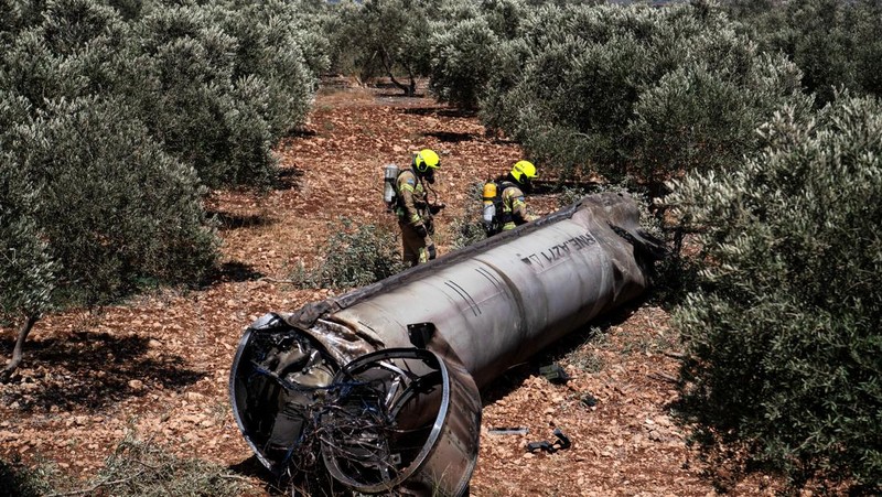 Orang-orang melihat sisa-sisa rudal balistik setelah serangan rudal Iran terhadap Israel, di Israel utara, 24 Juni 2025. REUTERS/Avi Ohayon