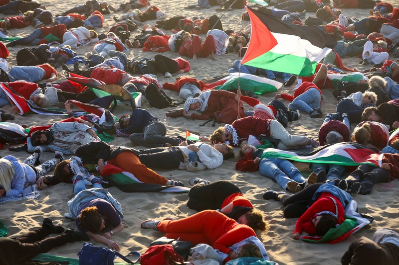 ISRAEL-PALESTINIANS/NATO-PROTEST Para pengunjuk rasa pro-Palestina berbaring di pasir, saat mereka berdemonstrasi di pantai Zuiderstrand menentang kekerasan di Gaza, di sela-sela KTT NATO, di Den Haag, Belanda, 24 Juni 2025. REUTERS/Thilo Schmuelgen