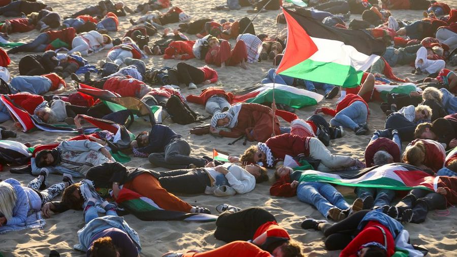 ISRAEL-PALESTINIANS/NATO-PROTEST Para pengunjuk rasa pro-Palestina berbaring di pasir, saat mereka berdemonstrasi di pantai Zuiderstrand menentang kekerasan di Gaza, di sela-sela KTT NATO, di Den Haag, Belanda, 24 Juni 2025. REUTERS/Thilo Schmuelgen