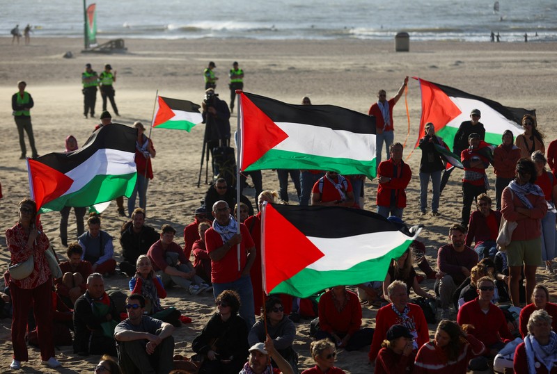 ISRAEL-PALESTINIANS/NATO-PROTEST Para pengunjuk rasa pro-Palestina berbaring di pasir, saat mereka berdemonstrasi di pantai Zuiderstrand menentang kekerasan di Gaza, di sela-sela KTT NATO, di Den Haag, Belanda, 24 Juni 2025. REUTERS/Thilo Schmuelgen