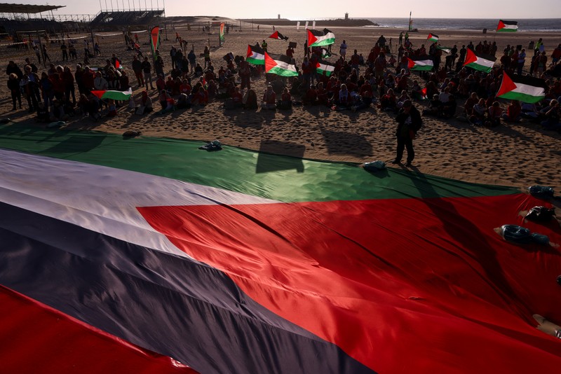 ISRAEL-PALESTINIANS/NATO-PROTEST Para pengunjuk rasa pro-Palestina berbaring di pasir, saat mereka berdemonstrasi di pantai Zuiderstrand menentang kekerasan di Gaza, di sela-sela KTT NATO, di Den Haag, Belanda, 24 Juni 2025. REUTERS/Thilo Schmuelgen