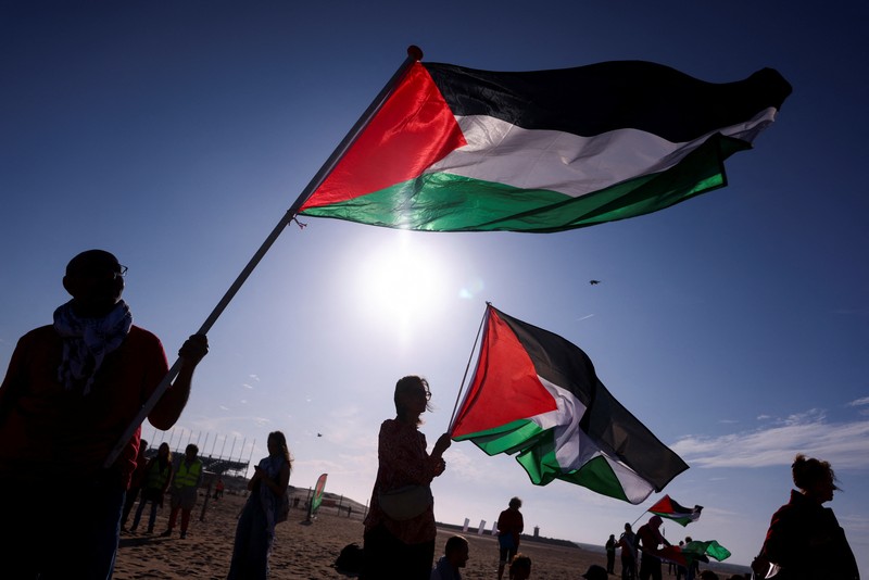 Para pengunjuk rasa pro-Palestina berbaring di pasir, saat mereka berdemonstrasi di pantai Zuiderstrand menentang kekerasan di Gaza, di sela-sela KTT NATO, di Den Haag, Belanda, 24 Juni 2025. REUTERS/Thilo Schmuelgen