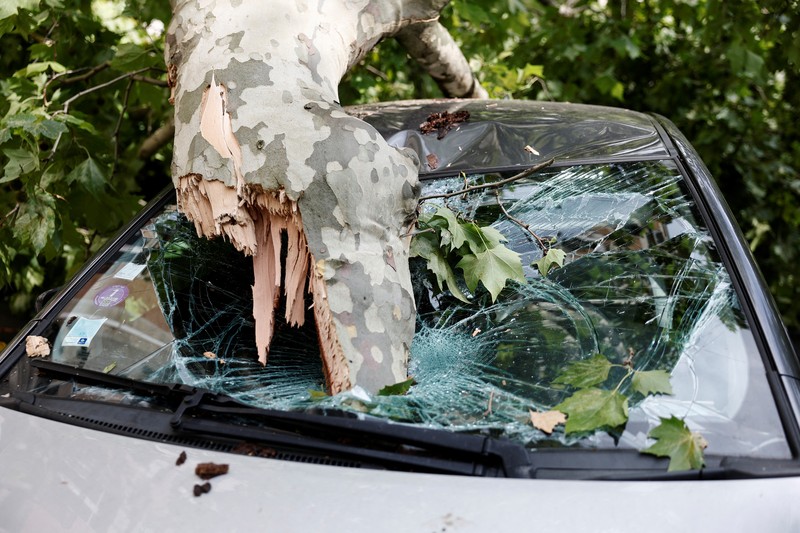 EUROPE-WEATHER/FRANCE Pemandangan cabang-cabang pohon yang patah di atas mobil yang rusak di jalan sehari setelah badai besar melanda Paris, Prancis, 26 Juni 2025. REUTERS/Benoit Tessier