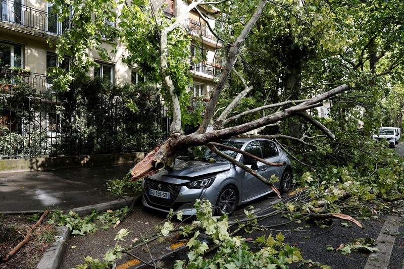 Pemandangan cabang-cabang pohon yang patah di atas mobil yang rusak di jalan sehari setelah badai besar melanda Paris, Prancis, 26 Juni 2025. REUTERS/Benoit Tessier