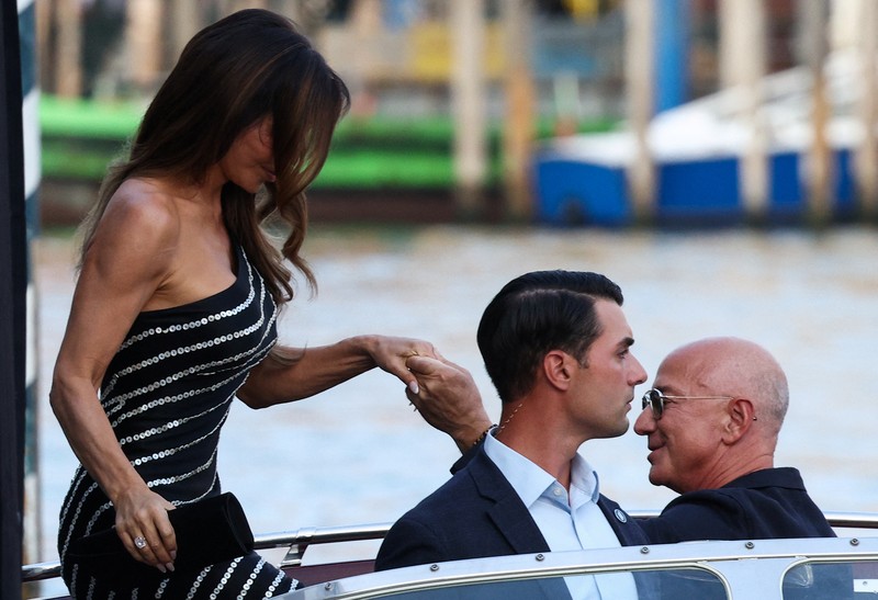 Jeff Bezos dan Lauren Sanchez menaiki perahu saat meninggalkan hotel Aman Venice, menjelang pernikahan mereka yang direncanakan, di Venesia, Italia, 25 Juni 2025. Jeff Bezos dan Lauren Sanchez menaiki perahu saat meninggalkan hotel Aman Venice, menjelang pernikahan mereka yang direncanakan, di Venesia, Italia, 25 Juni 2025. (REUTERS/Guglielmo Mangiapane)