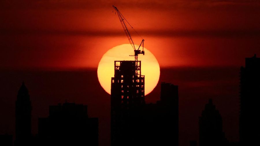 Matahari terbenam di balik cakrawala Manhattan saat peringatan panas ekstrem berlaku di New York City, AS, 23 Juni 2025. (REUTERS/Kylie Cooper)
