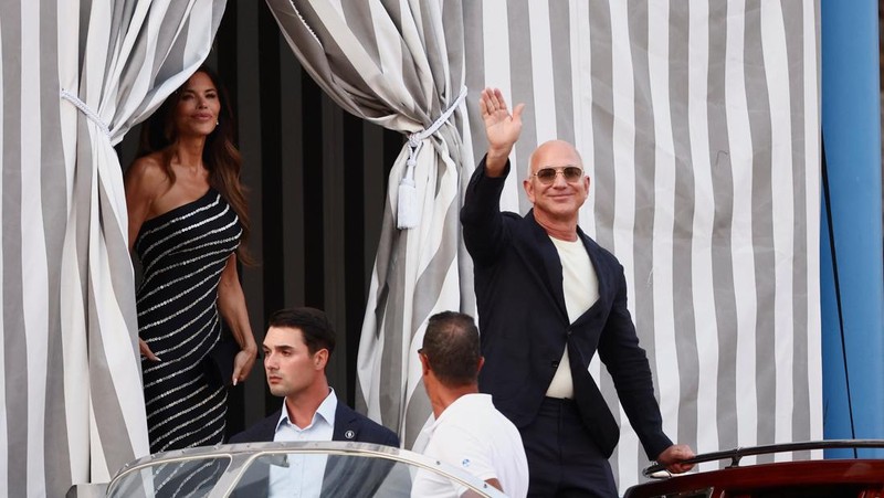 Jeff Bezos dan Lauren Sanchez menaiki perahu saat meninggalkan hotel Aman Venice, menjelang pernikahan mereka yang direncanakan, di Venesia, Italia, 25 Juni 2025. (REUTERS/Guglielmo Mangiapane)