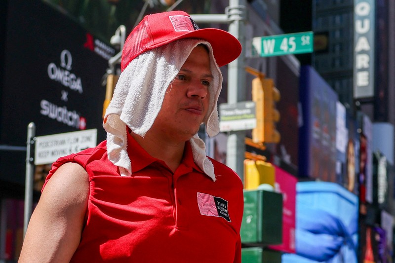 Seorang pengunjung National Mall memegang payung untuk melindungi diri dari terik matahari, di tengah gelombang panas berbahaya yang melanda wilayah timur Amerika Serikat, di Washington, D.C., AS, 25 Juni 2025. (REUTERS/Kevin Lamarque)