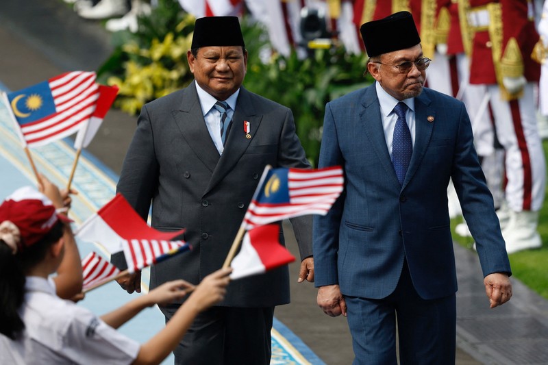 Presiden Indonesia Prabowo Subianto dan Perdana Menteri Malaysia Anwar Ibrahim memeriksa para pengawal kehormatan saat upacara penyambutan pertemuan mereka di Istana Merdeka, di Jakarta, Indonesia, 27 Juni 2025. (REUTERS/Ajeng Dinar Ulfiana)