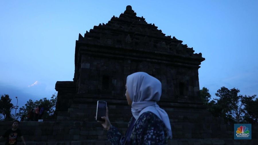 Sejumlah pengunjung mengabadikan situs warisan budaya Jogja di kawasan Dusun Groyokan, Desa Sambirejo, Kecamatan Prambanan, Kabupaten Sleman, Daerah Istimewa Yogyakarta, Jumat (27/6/2025). (CNBC Indonesia/Tri Susilo)