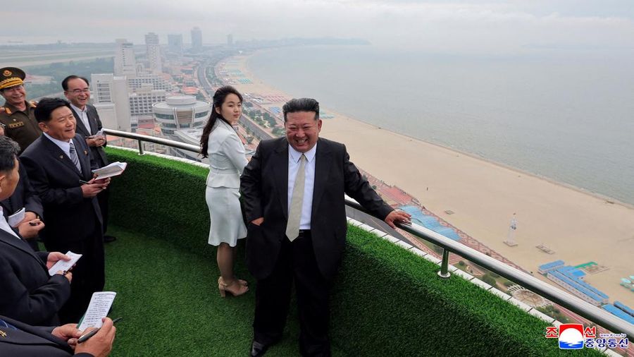 Pemimpin Korea Utara Kim Jong Un dan putrinya Kim Ju Ae berdiri di pantai selama upacara untuk merayakan selesainya Zona Wisata Pesisir Wonsan Kalma, di Wonsan, Korea Utara, 24 Juni 2025. (via REUTERS/KCNA)
