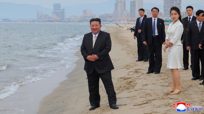 Pemimpin Korea Utara Kim Jong Un dan putrinya Kim Ju Ae berdiri di pantai selama upacara untuk merayakan selesainya Zona Wisata Pesisir Wonsan Kalma, di Wonsan, Korea Utara, 24 Juni 2025. (via REUTERS/KCNA)