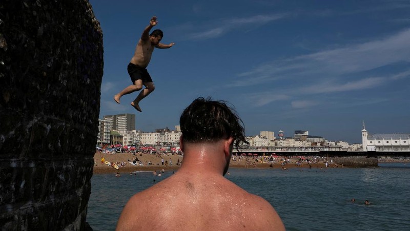 Turis melindungi diri dari terik matahari dengan payung selama gelombang panas musim panas pertama di Seville, Spanyol selatan, 29 Juni 2025. (REUTERS/Marcelo del Pozo)