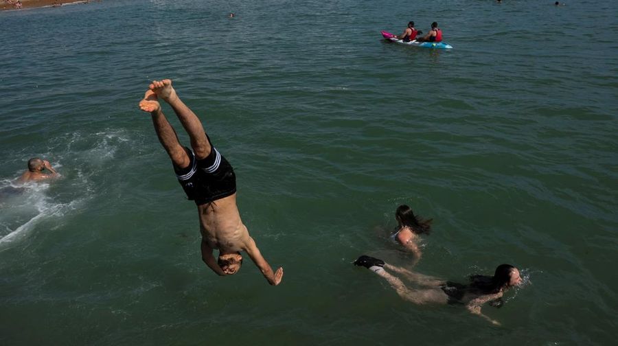 Seorang pria menyelam ke laut dekat Dermaga Istana Brighton saat cuaca panas di Brighton, Inggris, Minggu (29/6/2025). (REUTERS/Carlos Jasso)