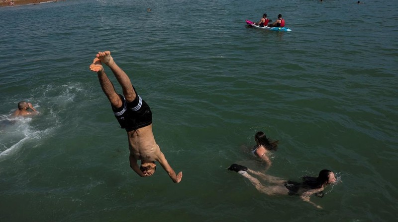 Seorang pria menyelam ke laut dekat Dermaga Istana Brighton saat cuaca panas di Brighton, Inggris, Minggu (29/6/2025). (REUTERS/Carlos Jasso)