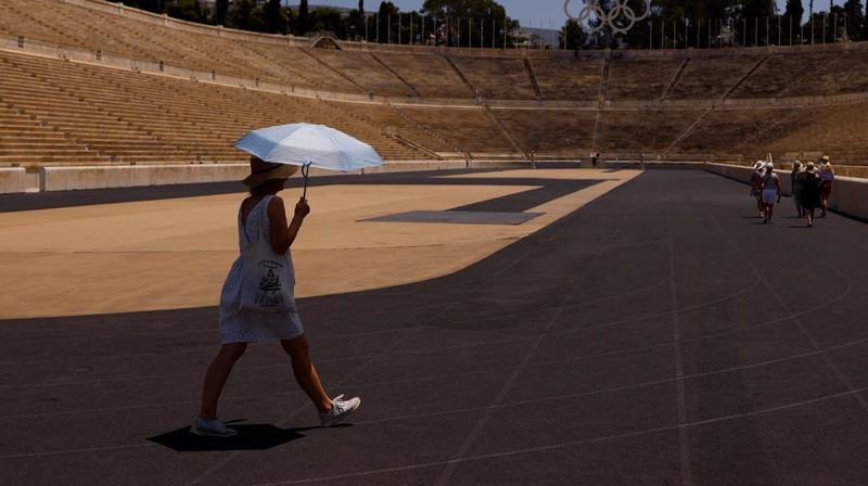 Turis melindungi diri dari terik matahari dengan payung selama gelombang panas musim panas pertama di Seville, Spanyol selatan, 29 Juni 2025. (REUTERS/Marcelo del Pozo)