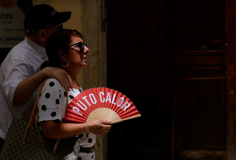 Turis melindungi diri dari terik matahari dengan payung selama gelombang panas musim panas pertama di Seville, Spanyol selatan, 29 Juni 2025. (REUTERS/Marcelo del Pozo)