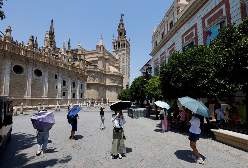 Turis melindungi diri dari terik matahari dengan payung selama gelombang panas musim panas pertama di Seville, Spanyol selatan, 29 Juni 2025. (REUTERS/Marcelo del Pozo) Turis melindungi diri dari terik matahari dengan payung selama gelombang panas musim panas pertama di Seville, Spanyol selatan, 29 Juni 2025. (REUTERS/Marcelo del Pozo)
