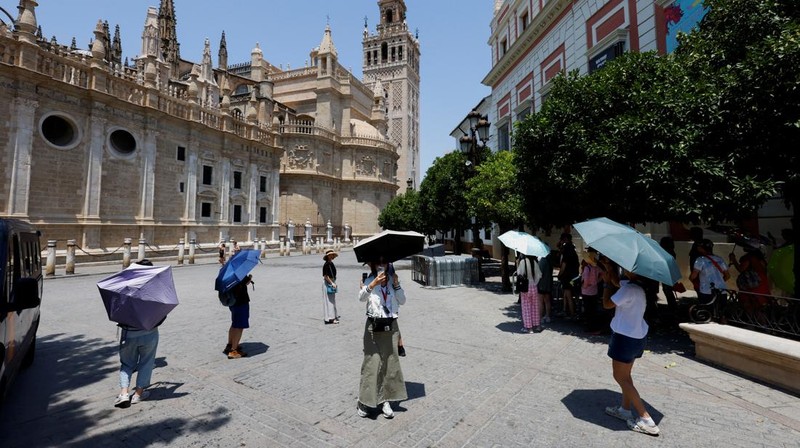 Turis melindungi diri dari terik matahari dengan payung selama gelombang panas musim panas pertama di Seville, Spanyol selatan, 29 Juni 2025. (REUTERS/Marcelo del Pozo)